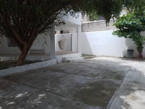 ein weißes Gebäude mit einem Baum und einer Tür in der Unterkunft Casa Fefe Huatulco in Tangolunda + 6 Fotos