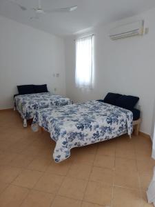 Zimmer mit 2 Betten mit blauer und weißer Bettwäsche in der Unterkunft Casa Fefe Huatulco in Tangolunda