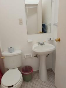 ein Badezimmer mit einer weißen Toilette und einem Waschbecken in der Unterkunft Casa Fefe Huatulco in Tangolunda