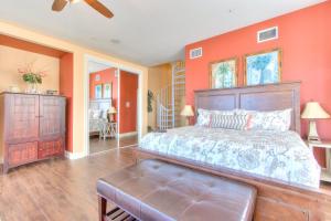 a bedroom with a large bed and orange walls at Bayway Luxury Waterfront Townhome & Pool in Clearwater Beach +34 photos