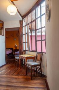 a room with a table and chairs and windows at Hotel Casa de las Rosas in Cuenca
