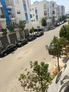 an empty street with cars parked in front of buildings at Martil Bel appartement lumineux, situé à seulement proche de la plage, idéal pour les vacances en famille ou entre amis, proche commerces in Martil