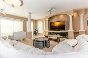 a living room with a white couch and a tv at Sweet Escape - Monthly Beach Rental in Clearwater Beach