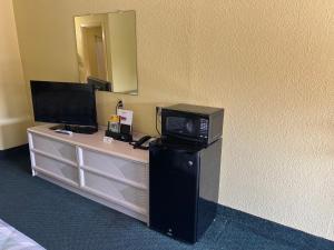 a television sitting on top of a dresser in a room at Antlers Inn in Cuero