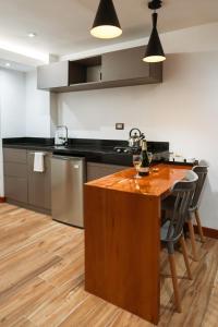 a kitchen with a wooden island with a counter top at San Blas Acogedor y Privado Studio C201 in Cusco +6 photos