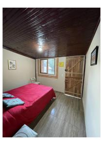 a bedroom with a red bed and a wooden ceiling at Pousada Montanha Mágica in São Thomé das Letras +42 photos