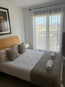 a bedroom with a bed with pillows and a window at Apartment C6 Phase 4 Mojon Hills, Isla Plana, CERTIFICATE OF EXCELLENCE in Isla Plana