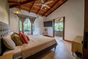 a bedroom with a bed and a ceiling fan at Modern Two Story Beach house in Puerto Viejo