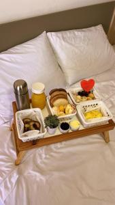 Una bandeja con diferentes alimentos sobre una cama. en Villa Mavi - Praia do Rosa, en Imbituba