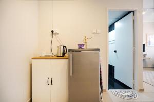a kitchen with a refrigerator and a door to a room at Cloud9 Studio Tiara Desaru in Desaru