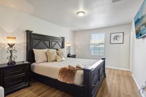 Un dormitorio con una cama negra y una ventana. en Modern Rental Near Medical Center, Six Flags, UTSA, La Cantera, Lackland AFB, en San Antonio