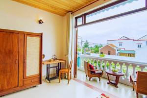 une chambre avec un balcon avec une table et des chaises dans l'établissement Heritage AnBang, à Hội An