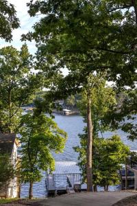 Sunrise BeachFunky Little Lakehouse - private dock and sunset view的享有带长凳和树木的湖泊美景