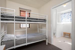 una camera con due letti a castello e un bagno di Cypress Cottage 26 Cypress Street Evans Head a Evans Head