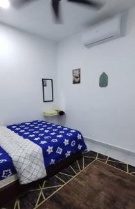 a bedroom with a bed with a blue and white blanket at SN HOMESTAY in Melaka