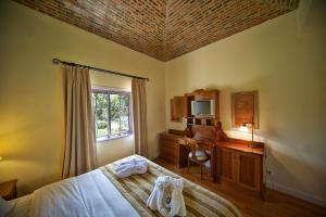 a bedroom with a bed and a desk and a television at Vila Alba Resort in Carvoeiro +37 photos