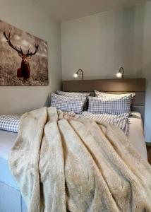 1 dormitorio con 1 cama con una pintura de ciervo en la pared en The Lodge Braunlage, en Braunlage
