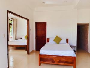 une chambre avec un lit et un miroir dans l'établissement Heritage AnBang, à Hội An