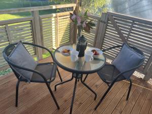 a table with two chairs and a bowl of food on a deck at Westmere Retreat in Westmere