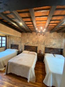 a bedroom with two beds and a chandelier at Hotel Casa Victoria in Antigua Guatemala +51 photos