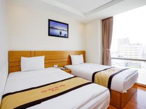 Giường trong phòng chung tại Nhat Linh Hotel & Suites Da Nang
