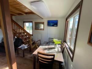 a dining room with a table and a staircase at Peaceful Acres Cabin 2 - Soldotna, AK in Kasilof