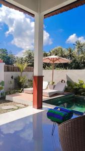 a house with a swimming pool and an umbrella at Pondok loji in Ubud