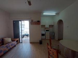 a living room with a table and a kitchen at Kapparis Apartment in Paralimni