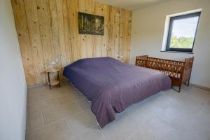 a bedroom with a bed in a room with wooden walls at Chalet Kato - Nieuw! Open vanaf 2 augustus 2024 in Barvaux +36 photos