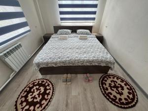科奇科尔Guest House Umar的卧室配有一张床,地板上铺有2个地毯。