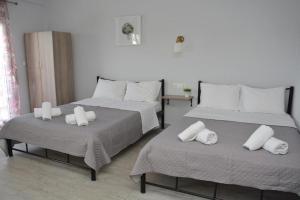 two beds with white pillows on them in a room at Gatos Village Studios & Apartments in Asprovalta