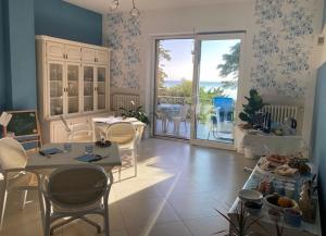 a living room with tables and chairs and a balcony at B&B Acqua e Sale in Roseto degli Abruzzi
