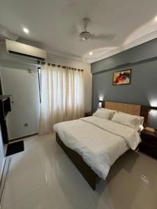 a bedroom with a large bed and a window at LUXE 2 BR Apartment Spacious And Modern Lounge in Karachi