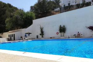 a large swimming pool in front of a white building at Precioso y amplio apartamento con vistas al mar in Torrenueva