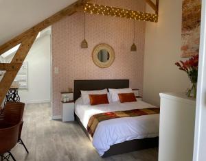 a bedroom with a large bed with lights on the wall at Atelier St Jean - Chambres d'hôtes in Montluçon +5 photos