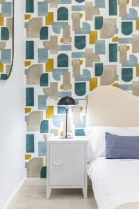 a bedroom with a bed and a geometric wall at APT - Plaza Mayor of Ávila - 1 min Alcazar in Avila