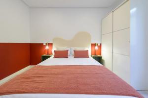 a bedroom with a large bed with red walls at APT - Plaza Mayor of Ávila - 1 min Alcazar in Avila