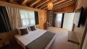 a bedroom with a bed and a television in a room at Perast Garden Hotel in Cıralı