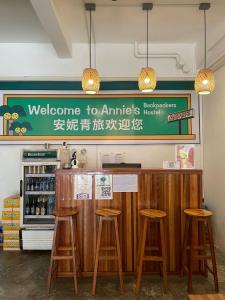 Un restaurante con un mostrador con taburetes y un cartel. en Annie Backpacker Hostel, en Ban Nongdouang