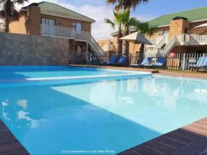 a swimming pool at a resort with blue water at Seaside Vacation Studio @ Shearwater Myoli Beach in Sedgefield