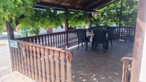 a patio with a table and chairs under a fence at Apartma Ferida in Bovec