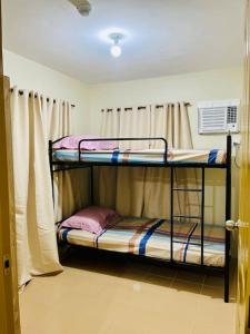 Dos literas en una habitación con ventana. en Maltuae Condotel, en Davao City