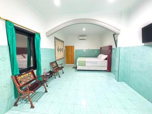a bedroom with a bed and two chairs in a room at Hotel Grand Bandara in Medan