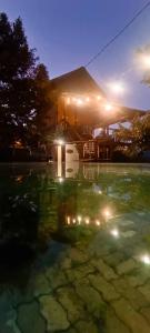 una casa con un riflesso nell'acqua di notte di BUKIT LIMAU REST HOUSE a Taiping