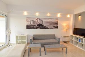 a living room with a couch and a tv at Athenian Riviera Varkiza next to the beach in Vari