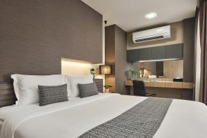 a hotel room with a large bed and a kitchen at Nap In Fest in Chiang Mai