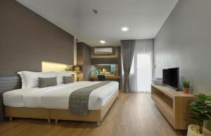 a bedroom with a large bed and a television at Nap In Fest in Chiang Mai
