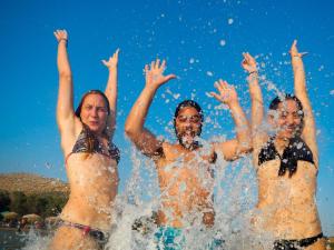 a group of people standing in the water at Athenian Riviera Varkiza next to the beach in Vari