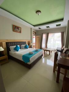 a bedroom with a large bed with blue pillows at Toraja Banua Hotel in Rantepao +7 photos