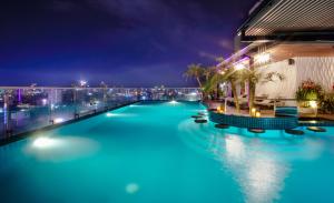 a swimming pool at night with a city in the background at Cicilia Hotels & Spa Danang in Danang